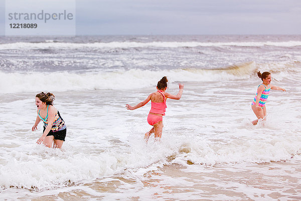 Drei Mädchen spielen in Meereswellen  Dauphin Island  Alabama  USA