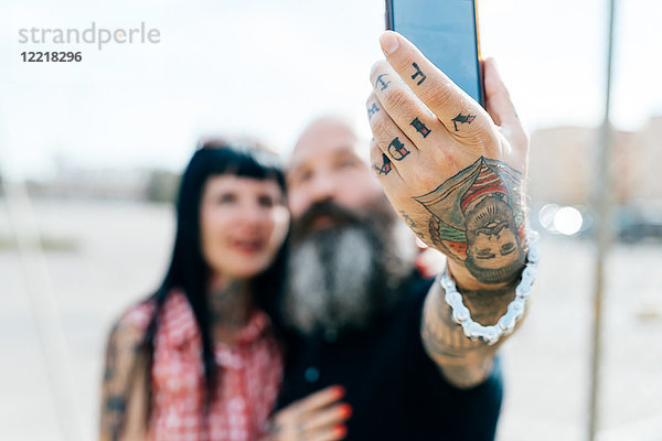 Ausgereiftes tätowiertes Hipster-Paar beim Selbermachen  Nahaufnahme der Hand