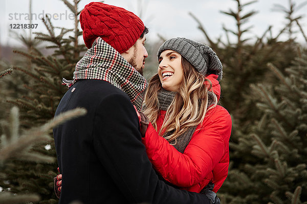Romantisches junges Paar kauft Weihnachtsbaum aus dem Wald