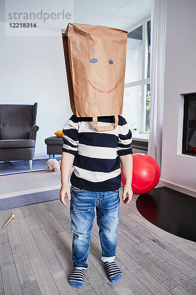 Bildnis eines kleinen Jungen mit brauner Tasche auf dem Kopf  gezeichnetes Gesicht auf brauner Tasche