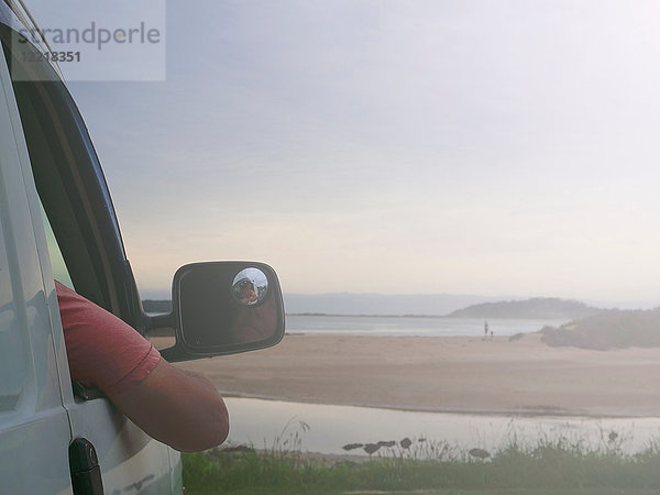 Älterer Mann sitzt im Auto und schaut auf die Küstenansicht  Broulee  New South Wales  Australien