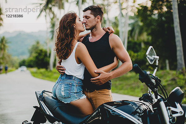 Romantisches junges Paar umarmt sich mit dem Motorrad auf einer Landstraße  Krabi  Thailand