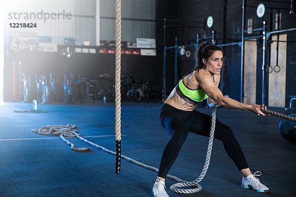 Frau trainiert in Turnhalle  Schlittentraining