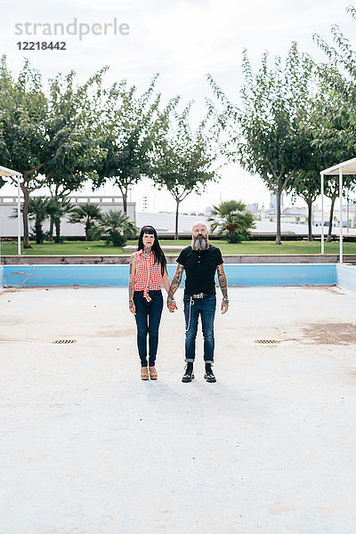 Reifes Hipster-Paar im leeren Schwimmbad stehend  Porträt  Valencia  Spanien