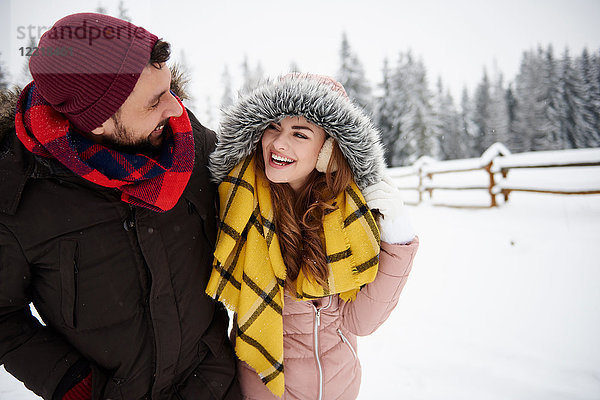 Junges Paar geht im Schnee spazieren