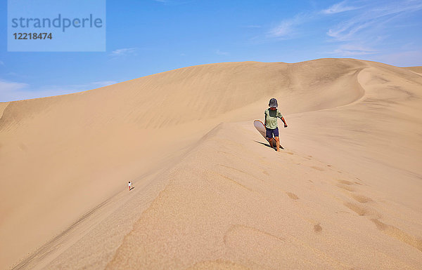 Junge mit Sandbrett auf Sanddünen  Ica  Peru
