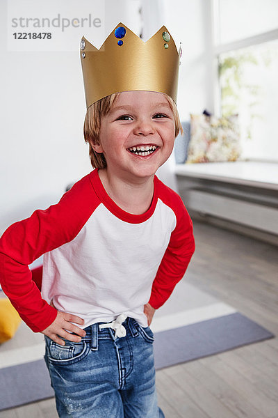 Porträt eines Jungen  der eine Pappkrone trägt und lächelt