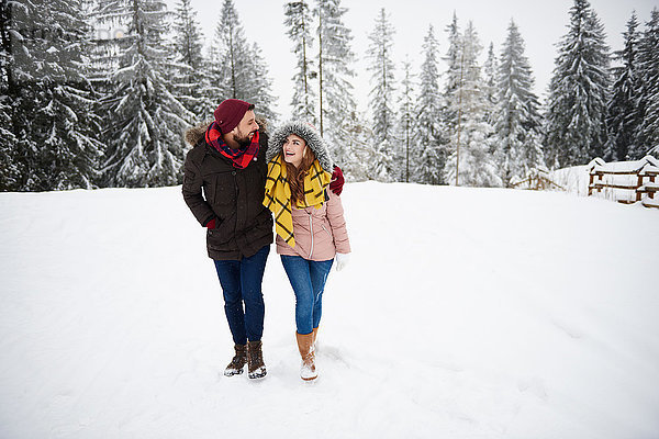 Junges Paar geht im Schnee spazieren