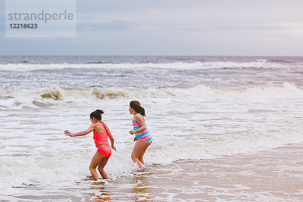 Zwei Mädchen spielen in Meereswellen  Dauphin Island  Alabama  USA
