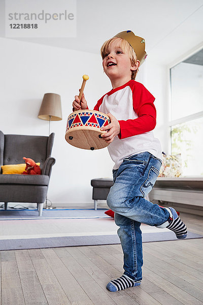 Junge mit Pappkrone  Spielzeugtrommel schlagend  niedriger Blickwinkel