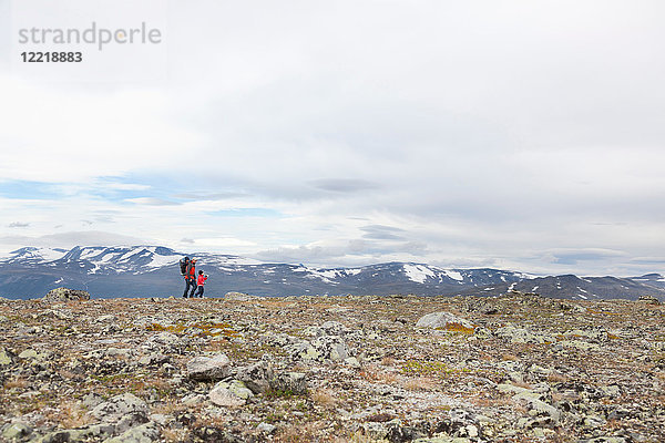 Fernblick eines Mannes mit Söhnen beim Wandern in der Berglandschaft  Jotunheimen-Nationalpark  Lom  Oppland  Norwegen