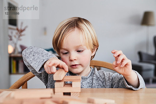 Porträt eines Jungen  Baustruktur mit Holzbausteinen