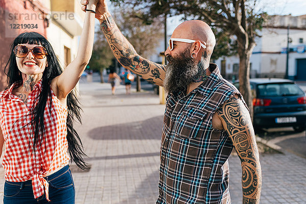 Ausgewachsenes Hipster-Paar tanzt auf dem Bürgersteig
