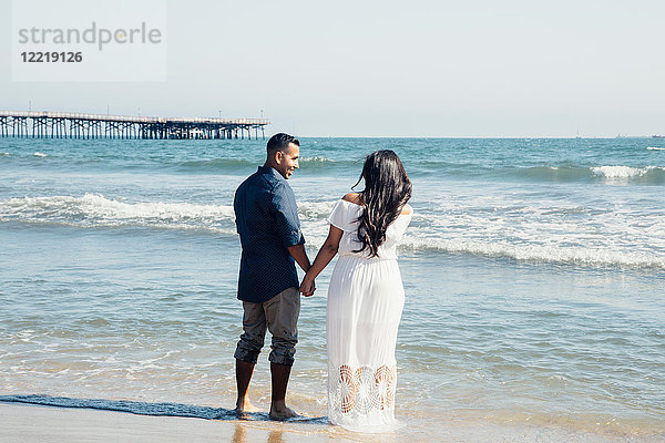 Paar am Strand stehend  Hände haltend  Rückansicht  Seal Beach  Kalifornien  USA