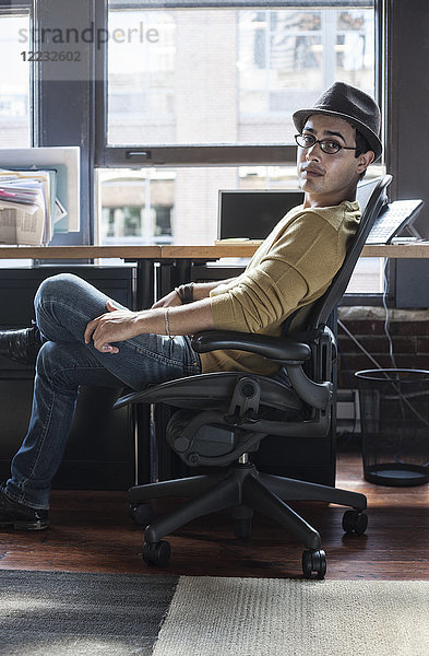 Hispanoamerikaner an seinem Büroarbeitsplatz in einem kreativen Büro.