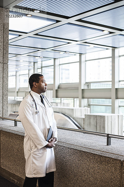 Schwarzer Mann Arzt im Laborkittel mit Stethoskop.