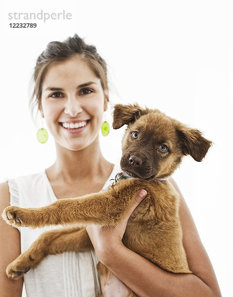 Porträt einer hispanischen Frau zu Hause mit ihrem Mischlingshund.