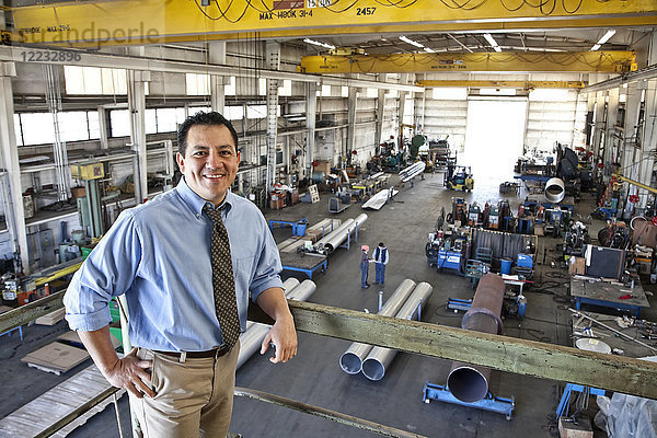 Hispanoamerikanischer Besitzer einer Blechfabrik  der über dem Fabrikgelände steht.