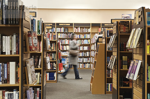 Kaukasische Frau blättert in einem Buchladen in Büchern.