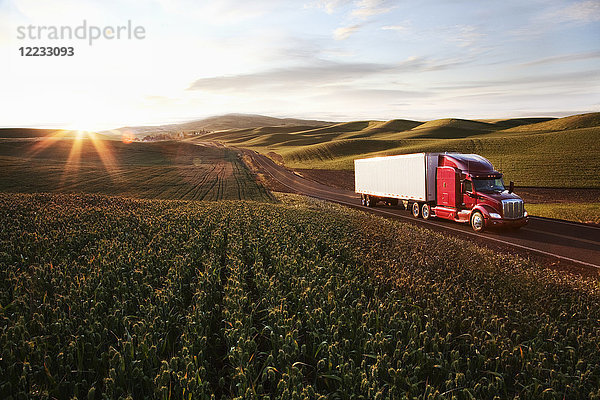 Ein kommerzieller Lastwagen der Peterbilt Class8 fährt bei Sonnenuntergang durch Ackerland im Osten Washingtons  USA.
