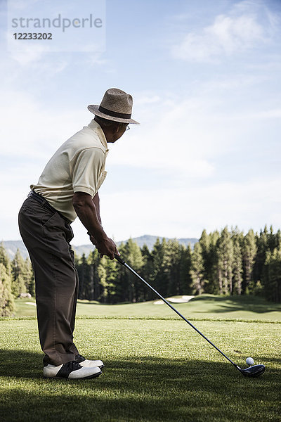 Senior-Golfer beim Abschlag während einer Golfrunde.