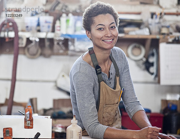 Blick auf eine lächelnde schwarze Fabrikarbeiterin an ihrem Arbeitsplatz in einer holzverarbeitenden Fabrik.