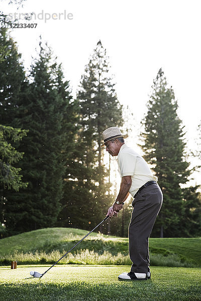 Senior-Golfer beim Abschlag während einer Golfrunde.