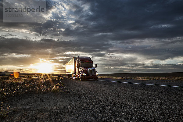 Kommerzieller Lastwagen bei Sonnenuntergang auf der Straße.
