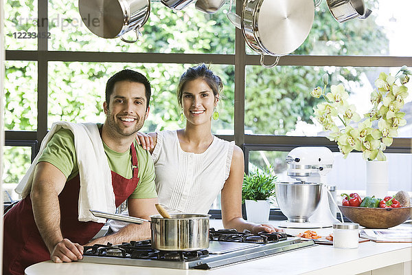 Lateinamerikanisches Ehepaar zu Hause in ihrer Küche beim gemeinsamen Kochen.