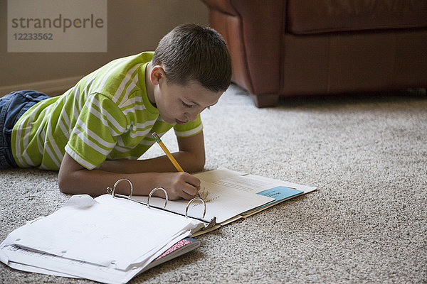 Junge Junge zu Hause bei den Hausaufgaben.