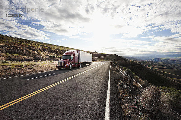 Kommerzieller Lastwagen fährt durch das hohe Wüstenland im Osten Washingtons  USA
