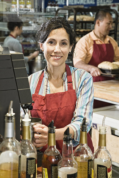 Hispanische Frau an der Kasse eines Bäckerei-/Kaffeeladens.