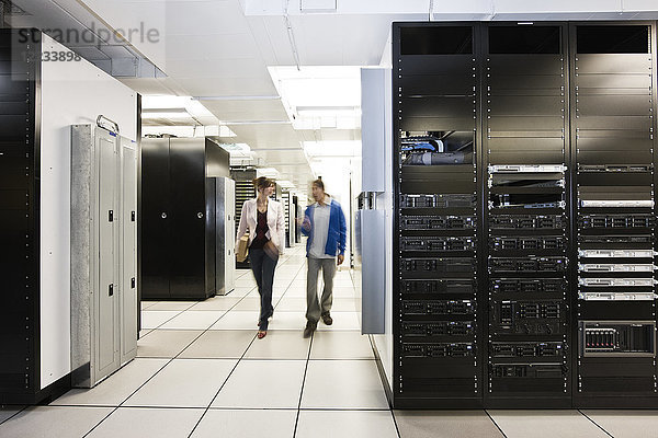 Computer-Serverraum-Racks mit Techniker im Hintergrund.