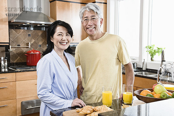 Asiatischer Mann und Frau in ihrer neuen Küche zum Frühstück.