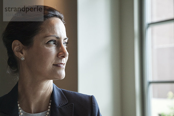 Kaukasische Geschäftsfrau neben einem Lobby-Fenster.