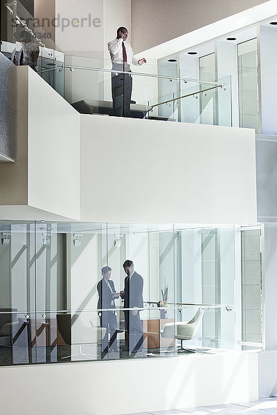 Geschäftsleute auf zwei Etagen eines großen Geschäftszentrums.