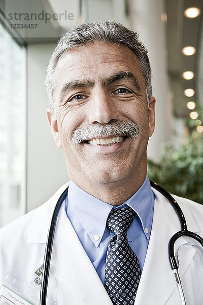 Mann aus dem Nahen Osten Arzt im Laborkittel mit Stethoskop.