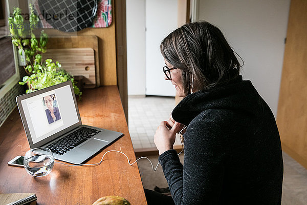 Seitenansicht der Geschäftsfrau Videogesprächskollegin am Laptop im Home-Office