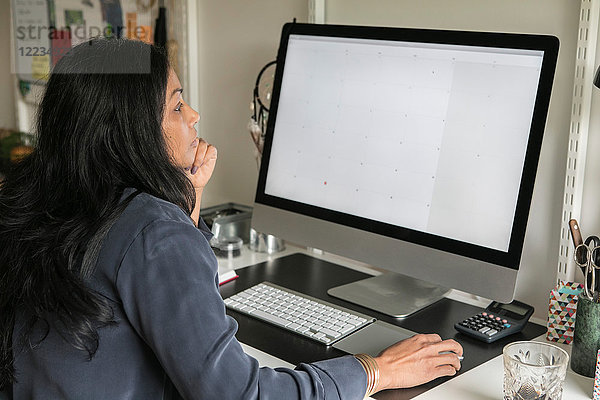 Seitenansicht der Geschäftsfrau am Computer im Home-Office