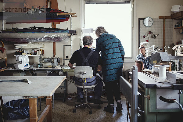 Seniorinnen und Seniorinnen diskutieren während der Arbeit in der Werkstatt
