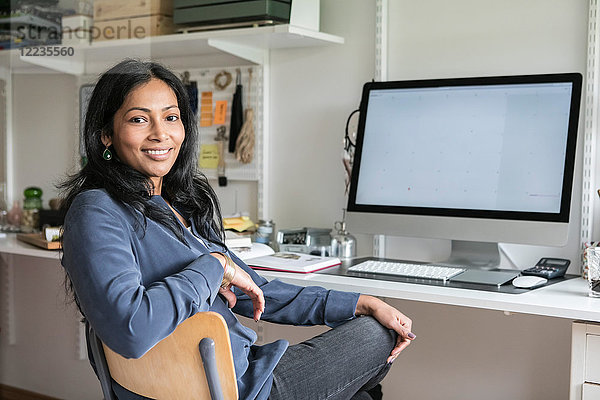 Porträt einer lächelnden Geschäftsfrau am Schreibtisch im Home Office