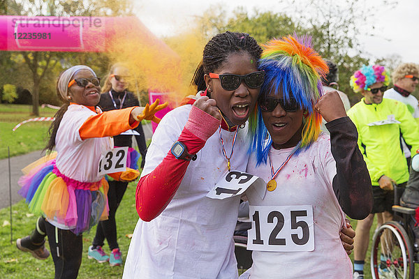 Porträt selbstbewusste  enthusiastische Läuferinnen  die beim Charity-Lauf im Park jubeln