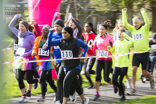 Begeisterte Läufer jubeln und rennen beim Charity-Lauf im Park