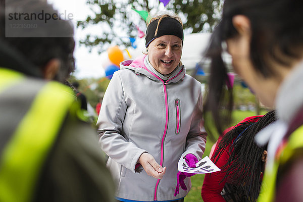 Lächelnde Frau mit Marathon-Lätzchen beim Benefizlauf