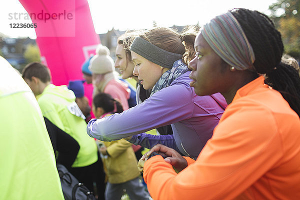 Fokussierte Läuferinnen mit pfiffigen Uhren  bereit für den Charity-Lauf.