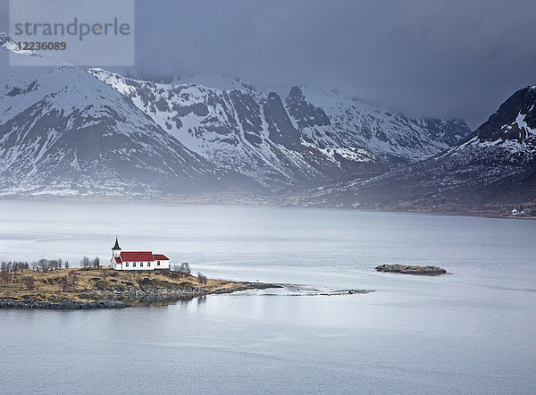 Abgelegene Kirche am Fjordufer unter verschneiten Bergen  Sildpoinesnet  Austvagoya  Norwegen