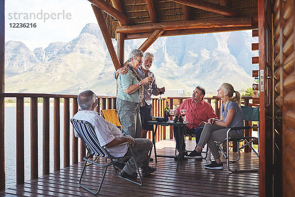 Aktives Seniorenpaar mit Weingläsern auf dem Balkon der Seehütte