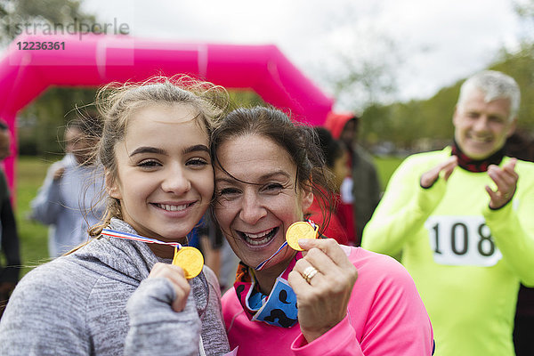 Porträt lächelnde  selbstbewusste Läuferinnen und Läufer mit Medaillen beim Benefizlauf