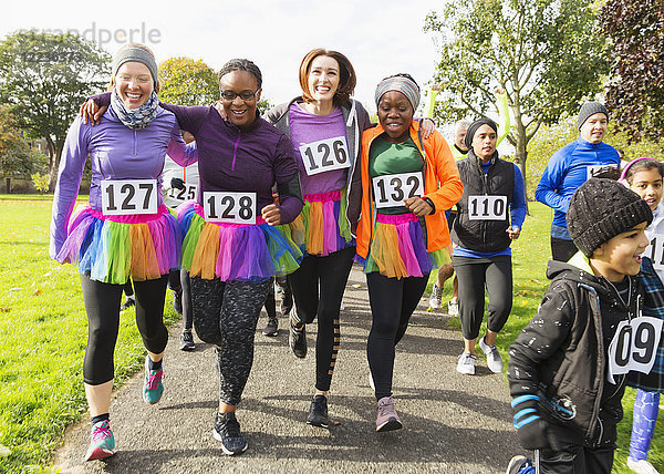 Lächelnde Läuferinnen im Tutus beim Benefizlauf im Park
