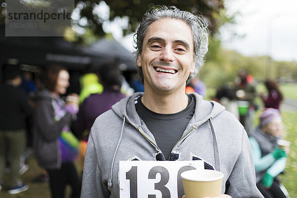 Portrait lächelnder Marathonläufer Trinkwasser